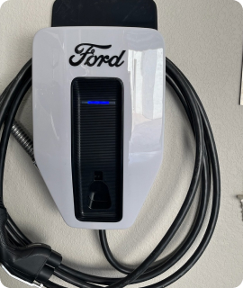 A ford charger is plugged into a wall.