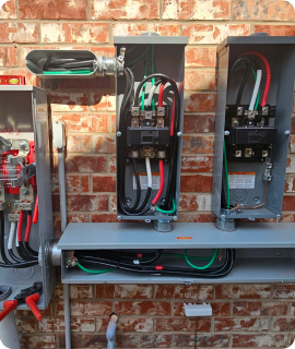 A box of electrical wires and wires on a brick wall.