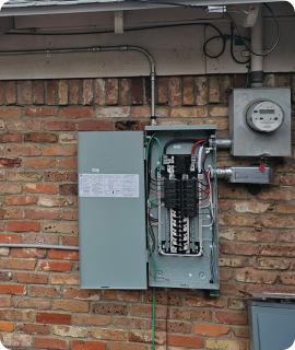 An electrical panel on a brick wall.